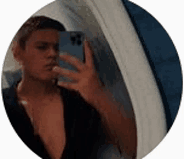 a man is taking a selfie in front of a mirror with his cell phone .