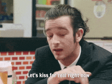 a man in a suit and tie is saying let 's kiss for real right now
