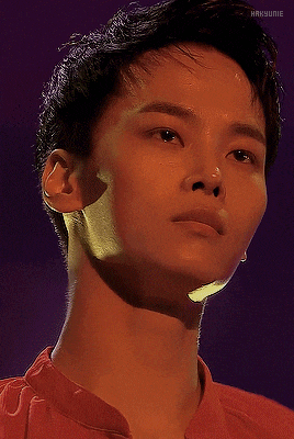 a close up of a man 's face with a purple background and the word hakunie on the bottom