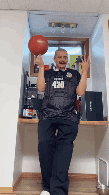 a man in a mexico 420 jersey holds a basketball in his hands