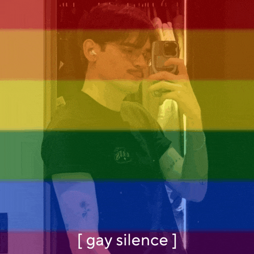 a man taking a selfie in front of a rainbow flag with the words gay silence