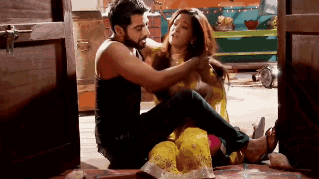 a man is kneeling down next to a woman who is sitting on the floor
