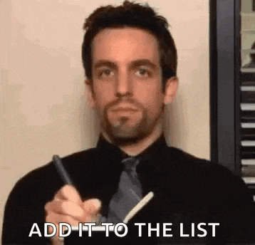 a man in a black shirt and tie is writing on a piece of paper .