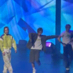 a group of men are dancing on a stage with a blue background