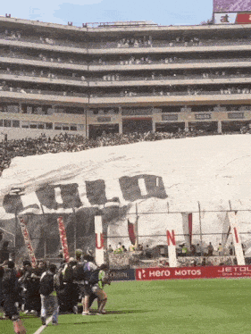 a soccer stadium with a banner that says hero motos