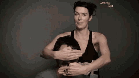a woman is covering a man 's face with her hands while he laughs .
