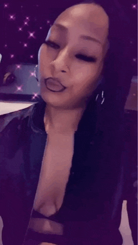 a woman wearing a plunging neckline and a nose ring is taking a selfie .