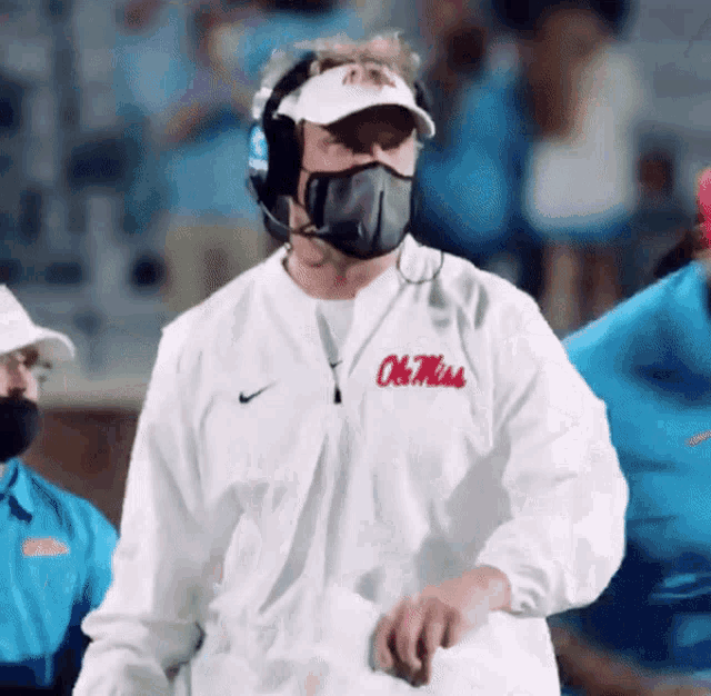 a man wearing a mask and a white jacket with the word ole miss on it