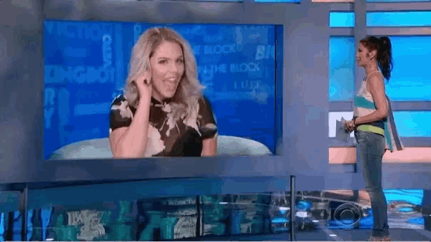 a woman talking on a cell phone in front of a screen that says block on it