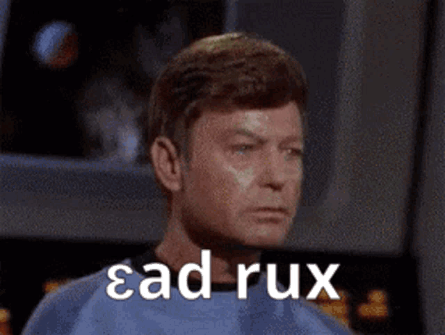 a man in a green shirt is sitting at a table with the words ead rux written on his face .