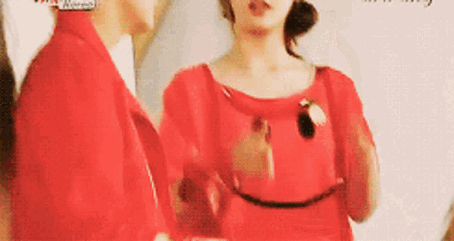 a woman in a red dress is standing next to a man