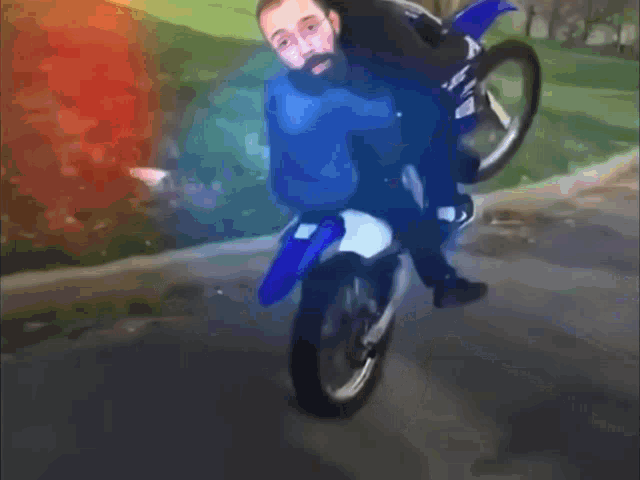 a man in a blue shirt is doing a trick on a dirt bike