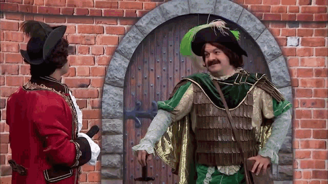 a man in a green and gold costume is standing in front of a door