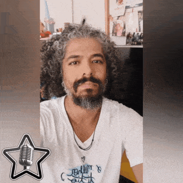 a man with curly hair and a beard is wearing a t-shirt that says " rolling out "