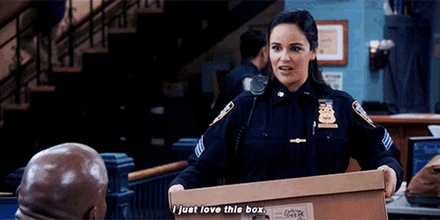 a woman in a police uniform is holding a box that says i just love this box
