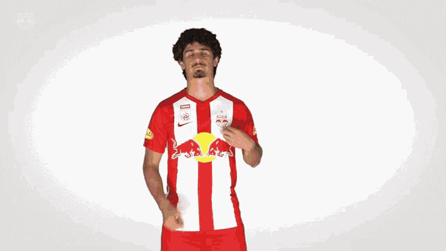 a man wearing a red and white striped shirt with a red bull on it