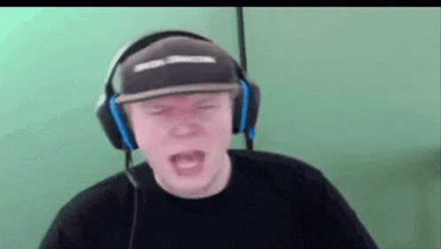 a man wearing headphones and a hat with the letter s on it