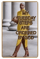 a woman wearing a yellow dress and brown boots is walking down the street .