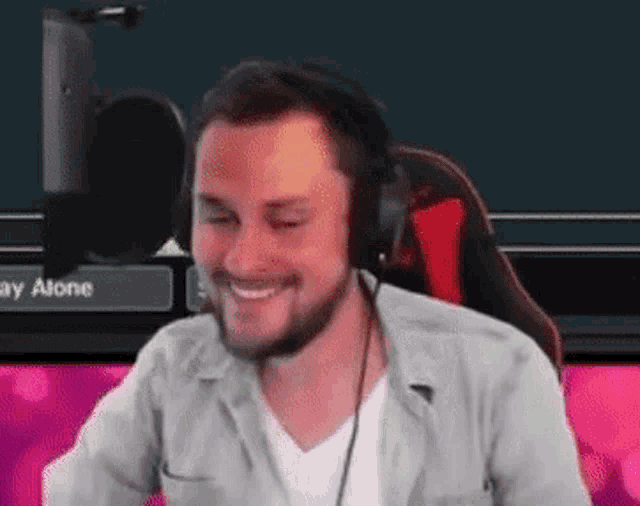 a man is wearing headphones and smiling while sitting in a chair .
