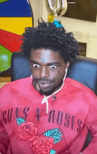 a man wearing a red guns n roses sweatshirt looks surprised