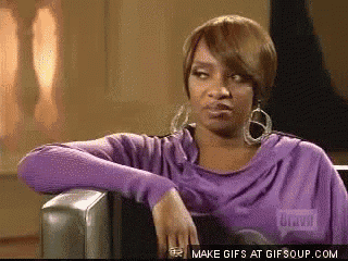 a woman in a purple sweater is sitting in a chair with her arm resting on the arm of the chair ..