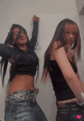 two girls are dancing together and one has a heart on her shirt