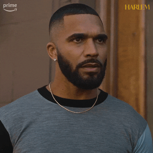 a man with a beard is wearing a shirt that says harlem