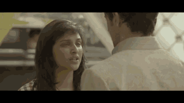 a man and a woman are looking at each other in a movie