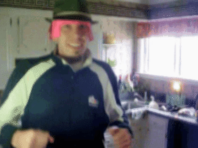 a blurry picture of a person wearing a green hat and a pink beanie
