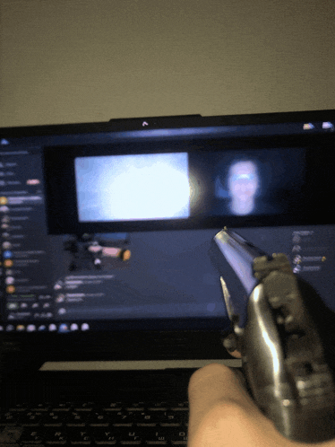 a person holding a gun in front of a computer screen