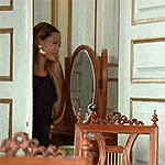 a woman is standing in front of a mirror in a room .