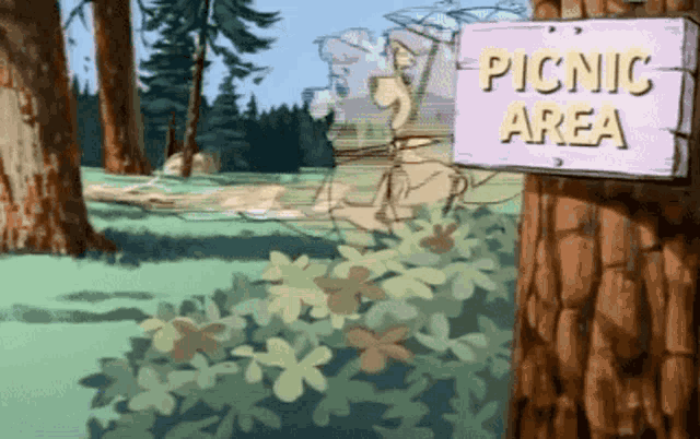 a picnic area sign on a tree in the woods