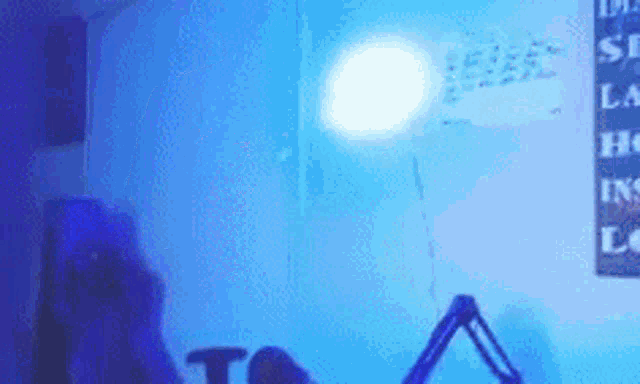 a person is sitting in front of a microphone in a room with blue lights on the wall .