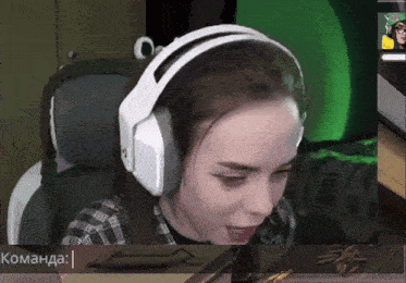 a woman wearing white headphones is playing a video game with a green background