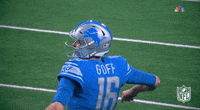 a football player wearing a helmet and a blue jersey with the number 12 on it
