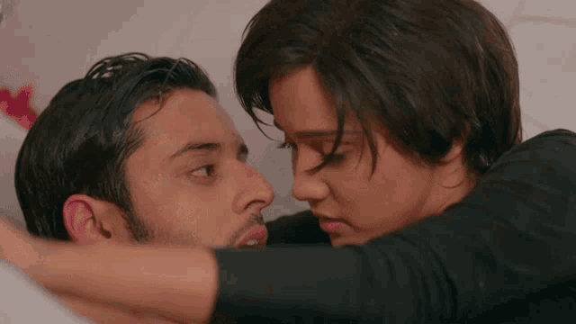 a man and a woman are hugging each other with their eyes closed
