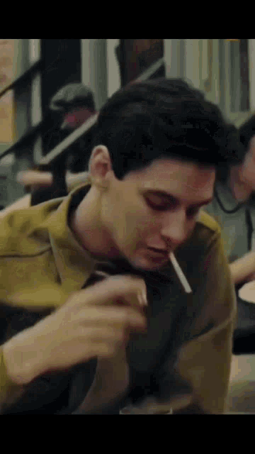 a man is smoking a cigarette in a restaurant