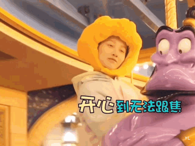 a person in a yellow hat is standing next to a purple statue with chinese characters on it