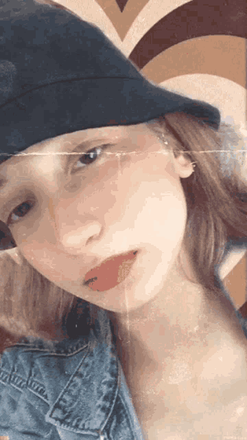 a girl wearing a black hat and a denim jacket