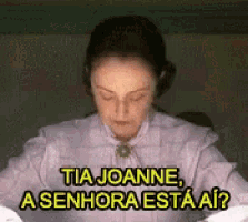 a woman in a white shirt is sitting at a table with her eyes closed .