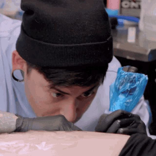 a tattoo artist is getting a tattoo on a person 's leg .