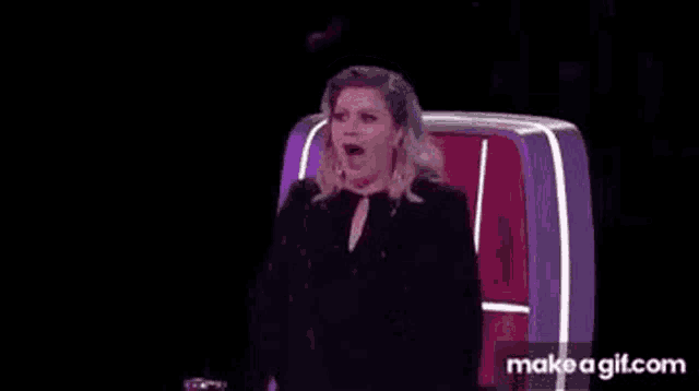 a woman is sitting in a chair with her mouth open on a television .