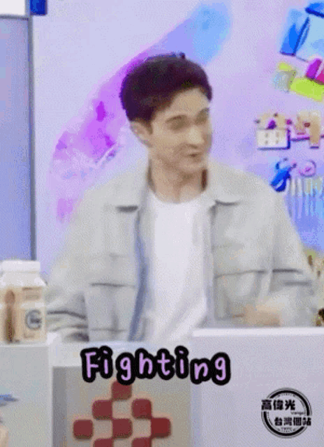 a man is standing in front of a box that says fighting on it