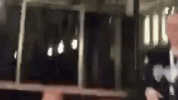 a blurry picture of a person holding a cell phone in front of a window .