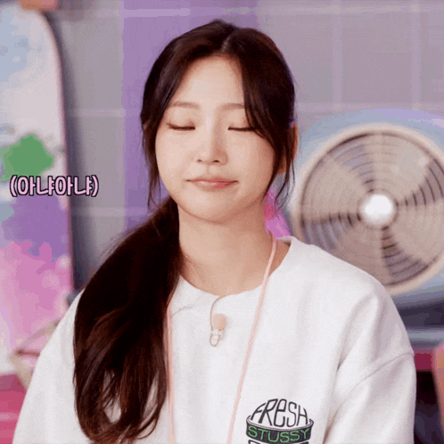 a woman wearing a white shirt that says fresh stussy on it