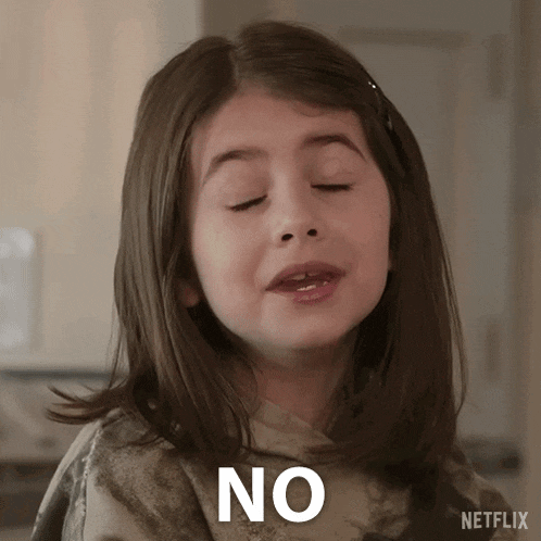 a young girl is making a funny face and saying no with her eyes closed .