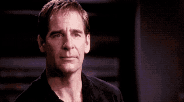 a man in a black shirt is making a funny face