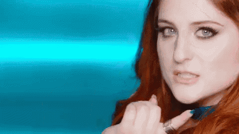 a close up of a woman 's face with red hair against a blue background
