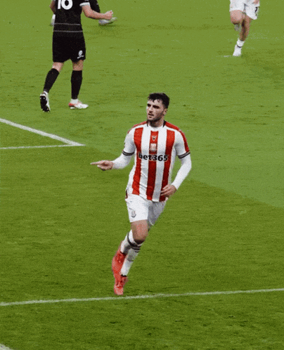 a soccer player wearing a red and white striped jersey with 365 on the front