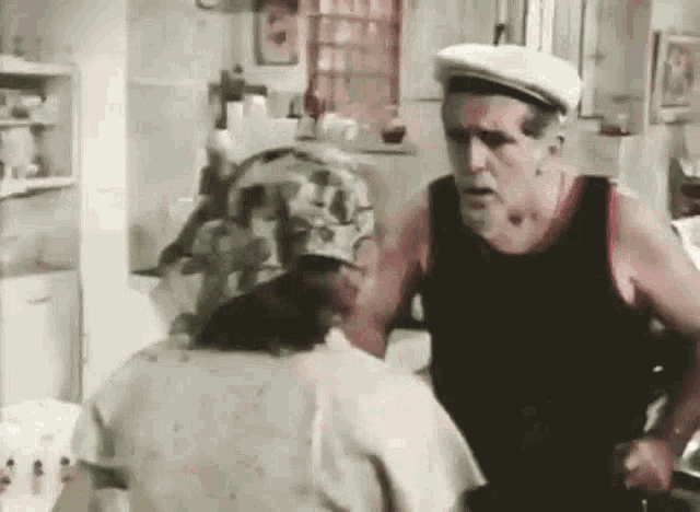 a man and a woman are talking in a kitchen .